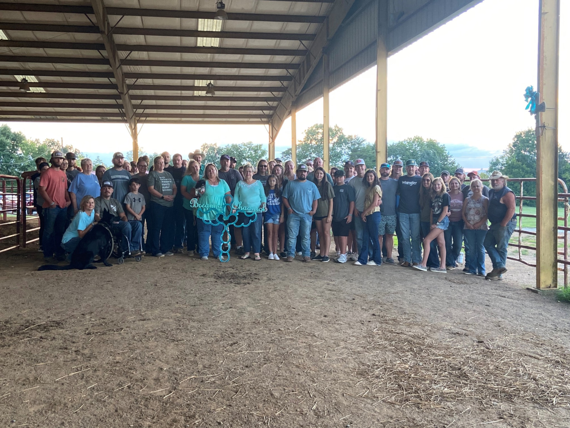 Bree's Legacy supporters gathered around turquoise memorial artwork at a community event.